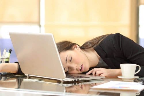 Kvinde sover på skrivebord