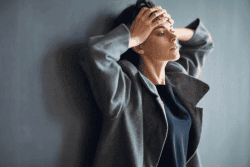 Kvinde tager sig til hoved