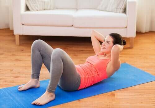 Kvinde træner maven med mavebøjninger
