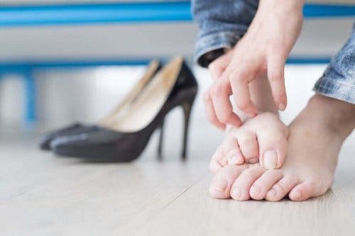 Kvindes fødder ved siden af højhælede sko