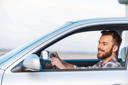 Smilende mand kører bil