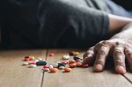 Mand på gulv med piller oplever medicinforgiftning