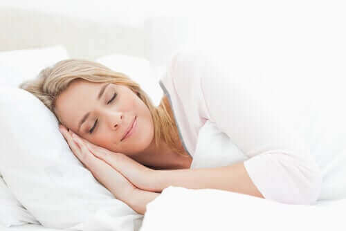 Smilende kvinde sover efter at have fulgt sunde sovevaner
