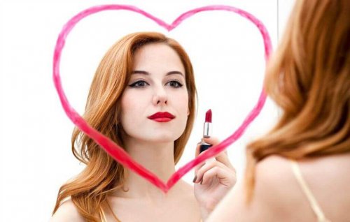 Kvinde maler hjerte på spejl med læbestift