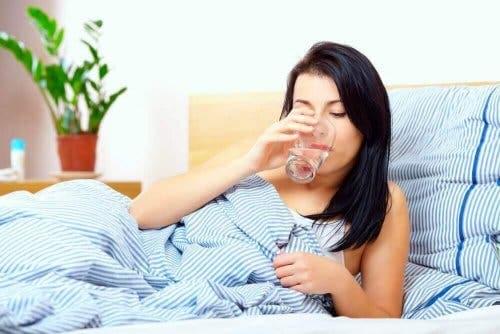 Kvinde drikker vand for at komme af med slim i halsen