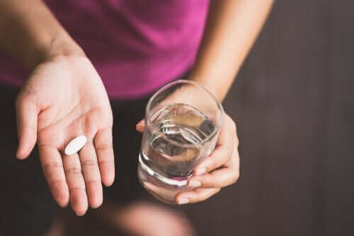 Kvinde med pille og vand i hænderne