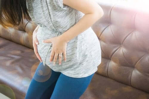 Gravid kvinde tager sig til mave