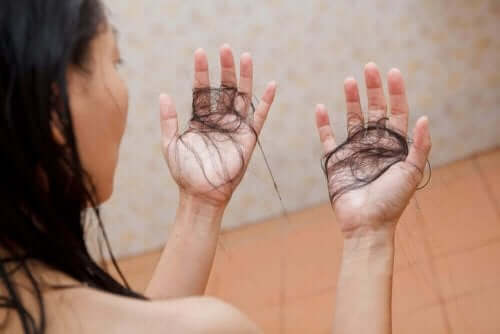 Kvinde med løse hår i hænderne oplever sæsonbestemt hårtab