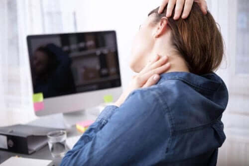 Person masserer nakke ved skrivebord