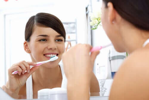 Kvinde børster tænder for at undgå bakterier i munden