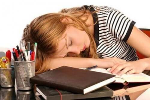Det er almindeligt, at personer med højt niveau af ferritin føler sig træt og svag, som denne pige, der sover på skrivebord