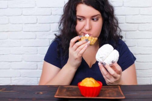 Kvinde med kager oplever konsekvenserne af at overspise