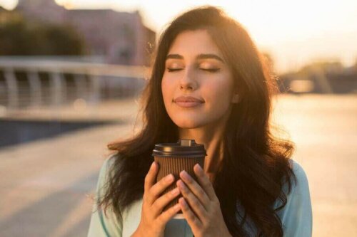 Kvinde nyder kaffe udenfor som en del af at forbedre sit følelsemsæssige helbred
