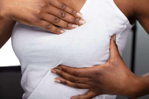 Kvinde, der masserer bryst, oplever sammenhængen mellem brystsmerter og menstruationscyklussen