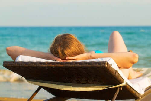 Kvinde soler sig på strand