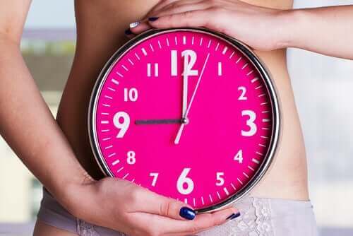 Kvinde med ur symboliserer, når kvinders menstruation synkroniserer