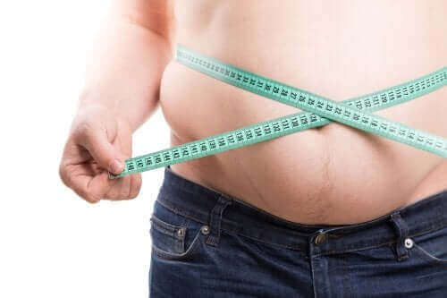 Overvægtig person måler sin mave