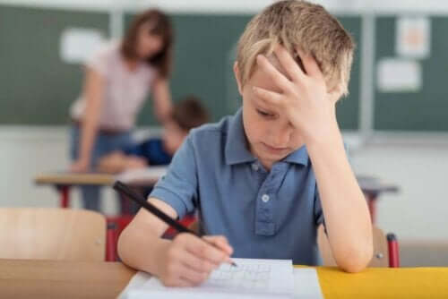 Dreng i klasseværelse tager sig til hoved grundet migræne hos børn