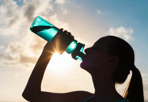 Kvinde drikker vand for at undgå ubalance i elektrolytter