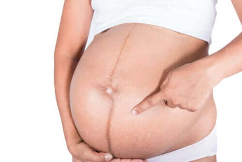 Gravid kvinde peger på sin mave