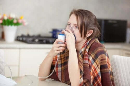 Kvinde med kold lungebetændelse anvender maske til at trække vejret