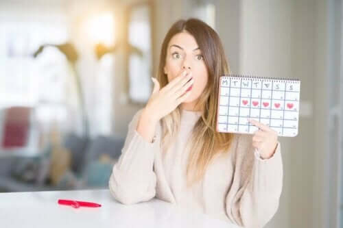 Overrasket kvinde med kalender over menstruationscyklus