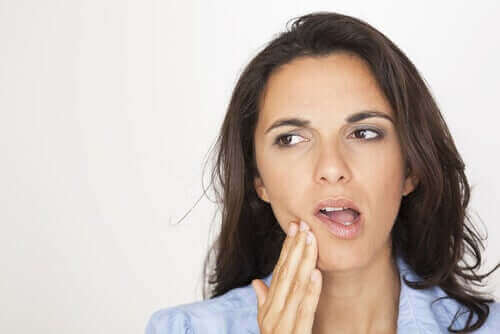 Kvinde med sensitive tænder tager sig til mund