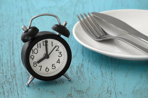 Ur ved siden af tom tallerken illustrerer faste før blodprøver