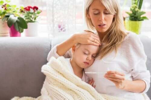Mor måler søns temperatur og vil behandle feber