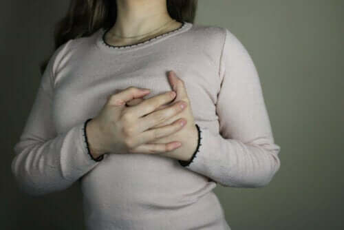Kvinde tager sig til bryst grundet smerter
