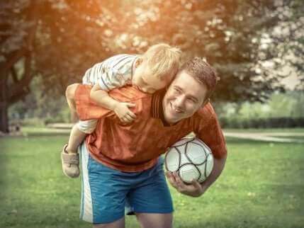 Far og søn med fodbold i park
