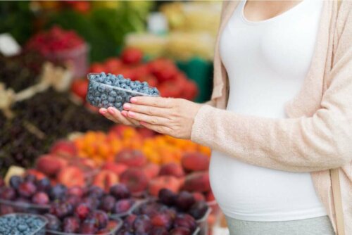 Gravid kvinde køber blåbær