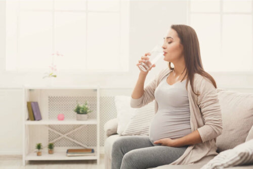 Kvinde drikker vand for at bekæmpe cystitis under graviditet