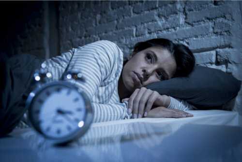 Kvinde, der ligger søvnløs i seng, oplever natteangst
