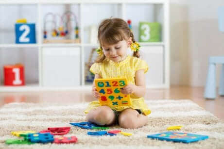 Lille pige leger med tal som eksempel på børn med autisme