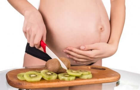 Gravid kvinde skærer kiwi