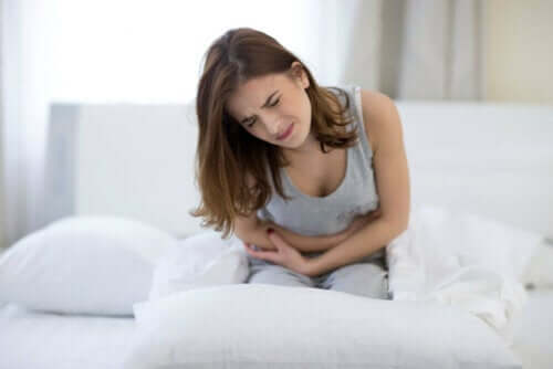 Kvinde i seng har mavepine