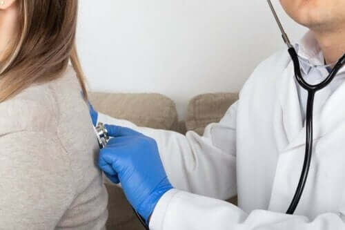 Læge lytter til en kvindes lunger