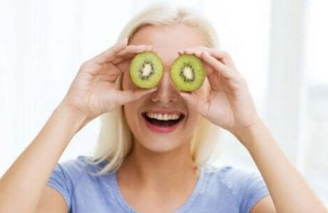 Kostens betydning bør man ikke undervurdere, og derfor står denne kvinde med sunde kiwier foran øjnene