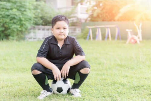 Dreng, der sidder på fodbold, symboliserer gode vaner hos børn