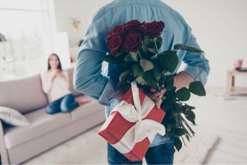 Mand overrasker kvinde med blomster og gave som et af de gængse kærlighedssprog
