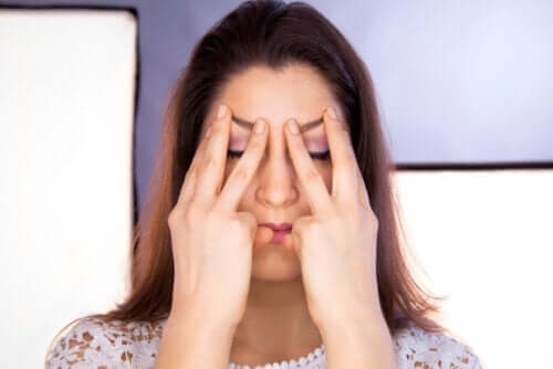 Kvinde illustrerer asymmetriske ansigter med fingrene