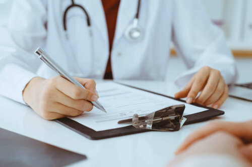 Læge udfylder et dokument