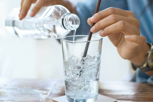 Kvinde hælder vand op i glas