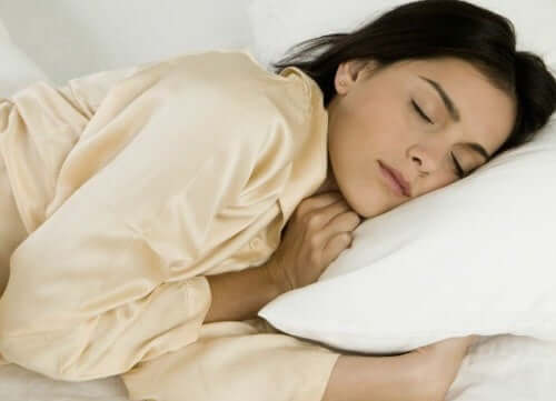 Kvinde sover på siden for at forebygge rygsmerter