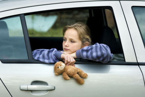 Pige i bil har bamse i hånden