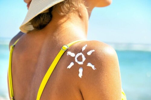 Solcreme på kvindes skulder ligner en sol