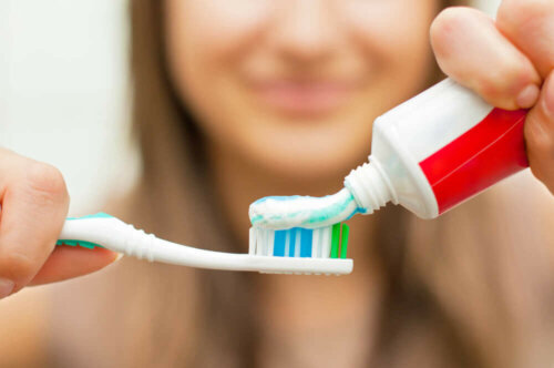 Kvinde kommer tandpasta på tandbørste