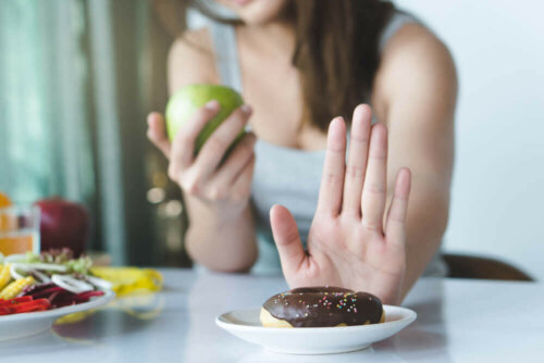 Kvinde med æble siger nej til donut