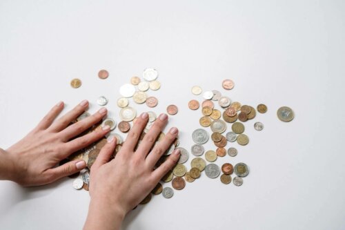 Hænder på mønter på bord